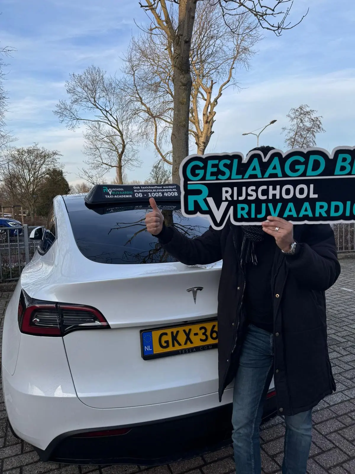 Geslaagde taxileerling met slagingsbord bij Rijschool Rijvaardig in Haarlem