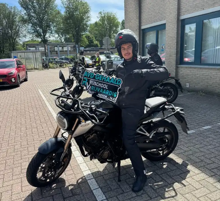 Leerlingen met AVB gehaald-bord op de motor bij Rijschool Rijvaardig Haarlem