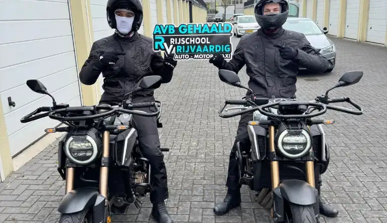 Leerlingen met AVB gehaald-bord op de motor bij Rijschool Rijvaardig Haarlem